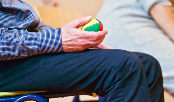 Hände halten einen kleinen bunten Ball